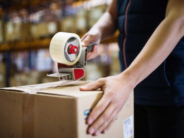 male-warehouse-worker-sealing-cardboard-boxes-PSKUTTE.jpg