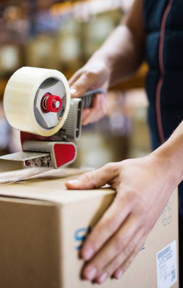 male-warehouse-worker-sealing-cardboard-boxes-PSKUTTE.jpg